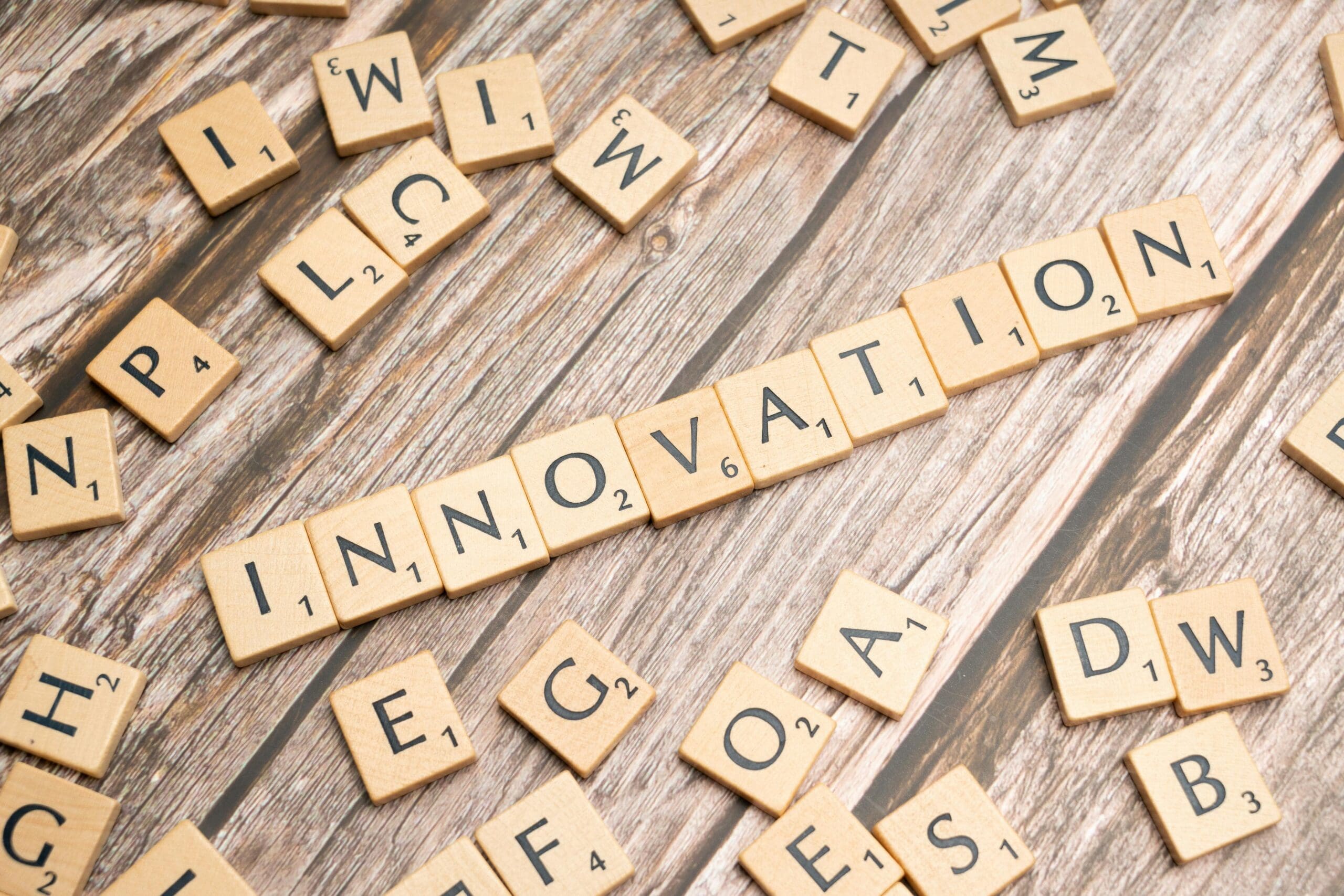 Creative display of 'Innovation' spelled with wooden letter tiles on a wooden surface.
