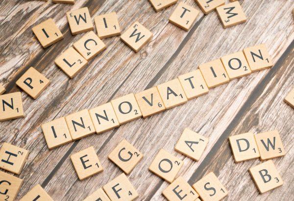 Creative display of 'Innovation' spelled with wooden letter tiles on a wooden surface.